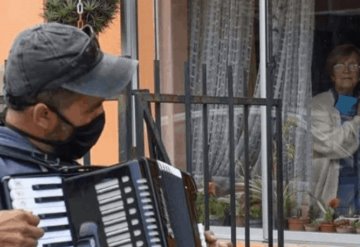 Toca el acordeón frente a la ventana de sus padres para animarlos en la cuarentena