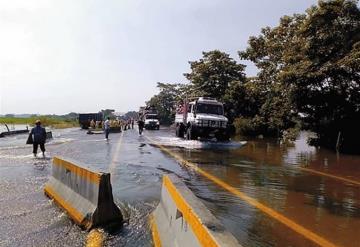 Ante cierre de carretera, trepan camiones para cruzar vado