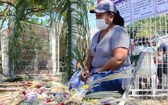 Mujer comerciante desde muy temprano inicia la venta de palma con motivo de domingo de ramos