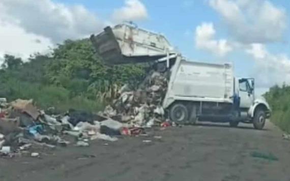 Camión recolector descarga los desechos a orilla de carretera
